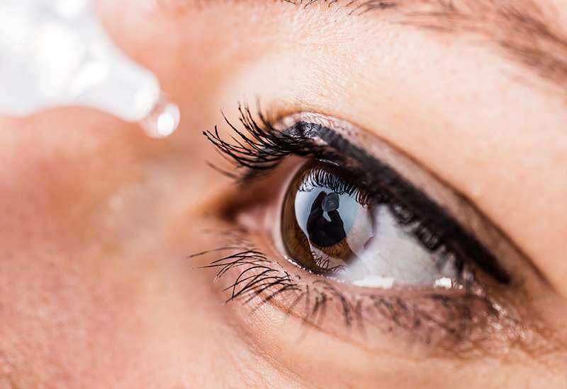Close-up of an eye with a drop of liquid about to be applied, highlighting eye care or hydration.